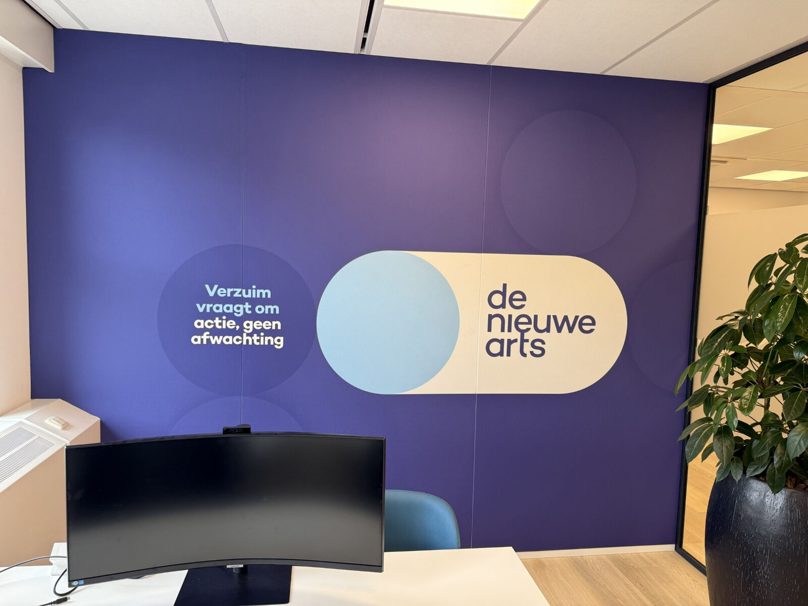 Een muurvullend ontwerp brengt kleur, huisstijl en akoestische wandbekleding samen.