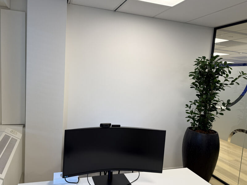 Een witte wand achter de werkplek.