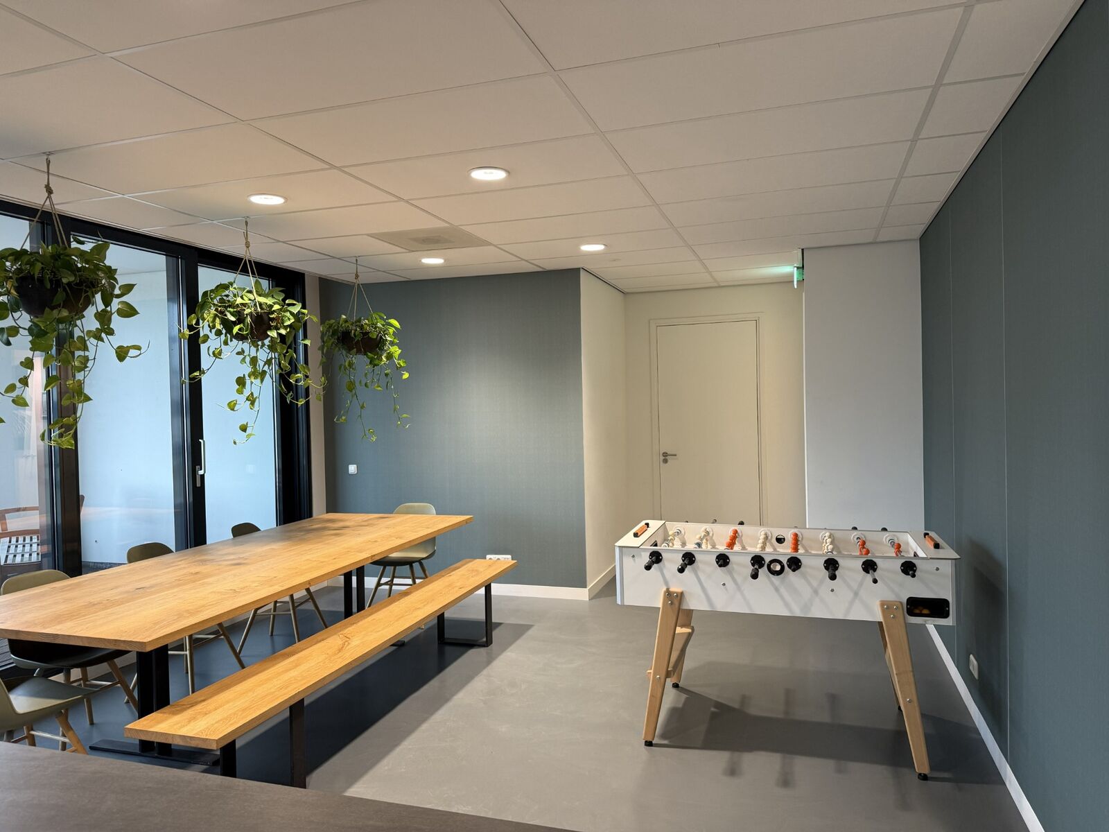 De kantine na oplevering: rustige groentinten, een subtiel patroon en de vertrouwde inrichting.