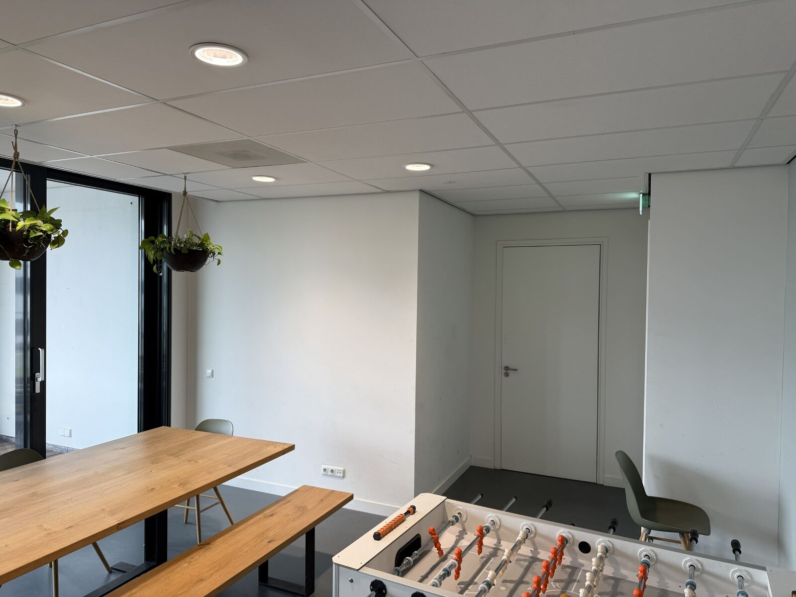 De eettafel, glazen gevel en gestucte wanden voor de aanpassing.