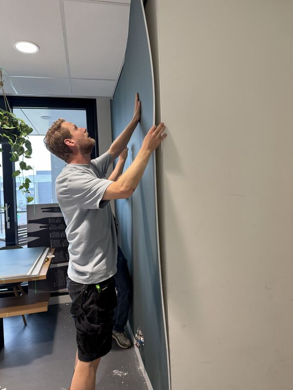 Een paneel wordt passend langs de wandhoek geplaatst.