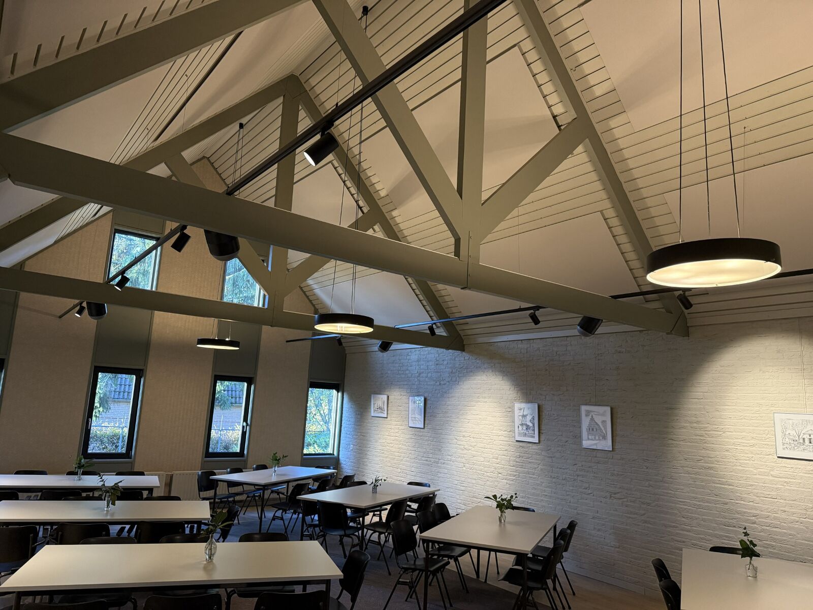 De zaal na plaatsing: akoestische panelen tussen de houten balken, afgestemd op het bestaande plafond.